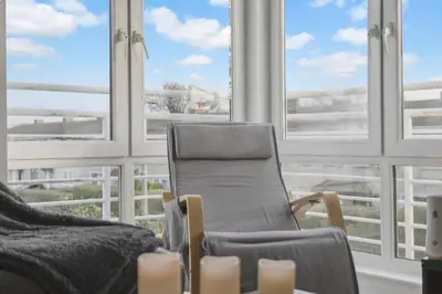 a living room with a chair and a large window at Cozy Edinburgh 2BR with CAR parking in Edinburgh