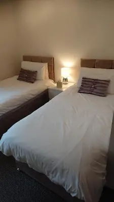 two beds sitting next to each other in a bedroom at Glenfern Guest House and a separate Cottage with its own private hot tub in Balloch