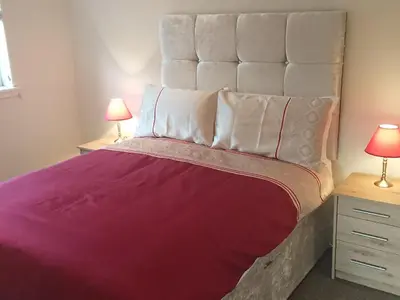 a bedroom with a large purple bed with two lamps at Glenfern Guest House and a separate Cottage with its own private hot tub in Balloch