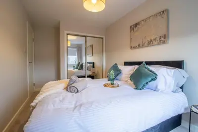 a bedroom with a large white bed with blue pillows at Angel House - 3 bedrooms close to Airdrie Centre in Airdrie