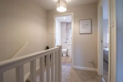 a hallway with a staircase leading to a bathroom at Angel House - 3 bedrooms close to Airdrie Centre in Airdrie