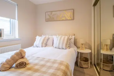 a bedroom with a large white bed with two side tables at Angel House - 3 bedrooms close to Airdrie Centre in Airdrie