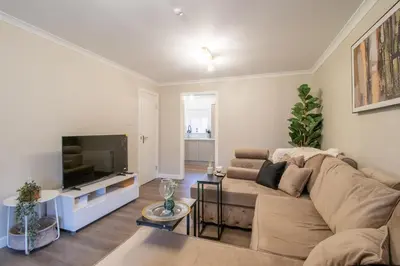 a living room with a couch and a flat screen tv at Angel House - 3 bedrooms close to Airdrie Centre in Airdrie