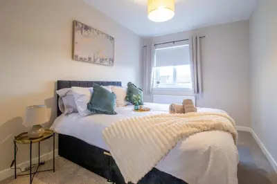 a bedroom with a bed with pillows and a window at Angel House - 3 bedrooms close to Airdrie Centre in Airdrie