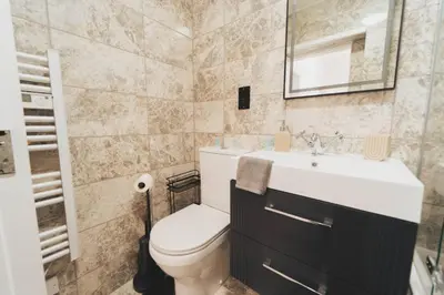 a bathroom with a toilet and a sink at Top Floor 1BR Wishaw Flat with Parking in Wishaw
