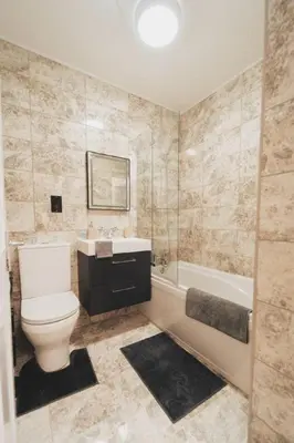 a bathroom with a toilet and a sink and a tub at Top Floor 1BR Wishaw Flat with Parking in Wishaw