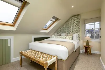 a bedroom with a king sized bed and windows at 3-Bed Georgian Townhouse Next to Wellbeing Clinic in Stirling