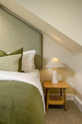 a bedroom with a bed and a table with a lamp at 3-Bed Georgian Townhouse Next to Wellbeing Clinic in Stirling