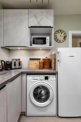 a kitchen with a washing machine and a refrigerator at 3-Bed Georgian Townhouse Next to Wellbeing Clinic in Stirling
