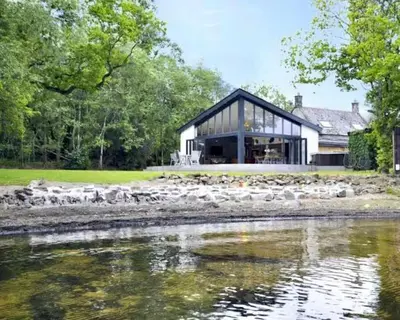 a house with a view of a body of water at Cameron North Lodge in Balloch