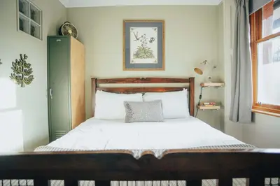 a bedroom with a bed with a wooden headboard at Snug 1 Bed Apartment in Edinburgh's Juniper Green in Edinburgh