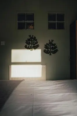 a bedroom with a bed and two trees on the wall at Snug 1 Bed Apartment in Edinburgh's Juniper Green in Edinburgh