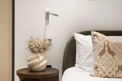 a vase sitting on a table next to a bed at Stylish 2-Bedroom Flat On Seven Sisters Rd in Moffat