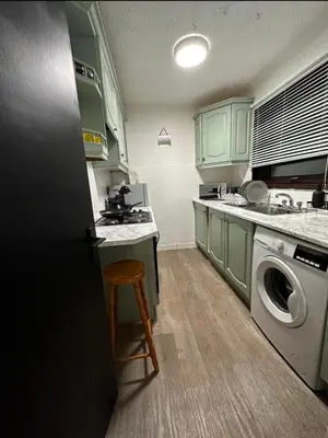 a kitchen with green cabinets and a washing machine at Hydro Secc House Glasgow 10 minute walk in Glasgow