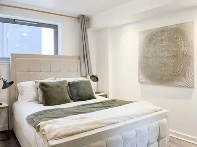 a bedroom with a large bed with a large window at Stunning River View City Centre Apartment in Glasgow