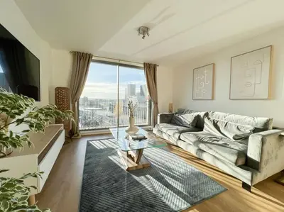 a living room with a couch and a glass table at Stunning River View City Centre Apartment in Glasgow
