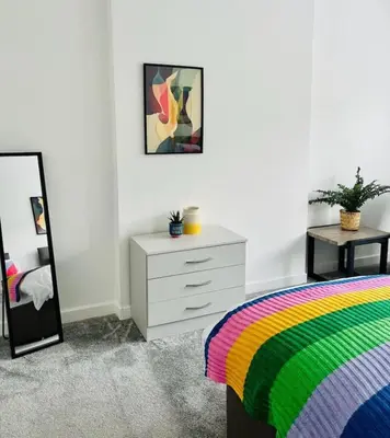 a bedroom with a bed and a dresser and a mirror at Clyde Fifty Two - Glasgow Apartment in Glasgow