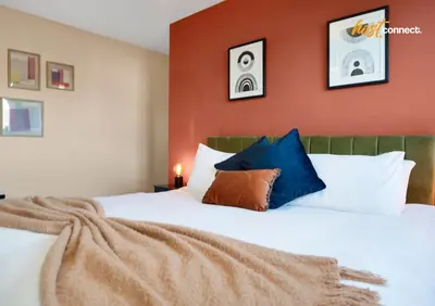 a bedroom with a large white bed with blue pillows at 3Bed House I Sleeps 6 I Dunfermline in Dunfermline