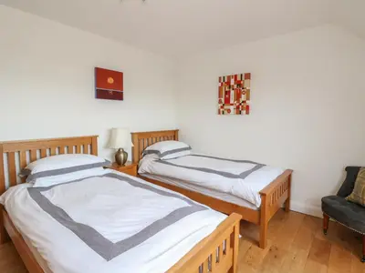 two twin beds in a room with a chair at Lurach House in Appin