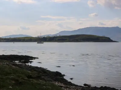 a large body of water with a boat in it at Lurach House in Appin