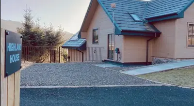 a house with a sign in front of it at Highland House in Lochearnhead