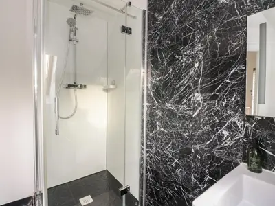 a bathroom with a shower with a black marble wall at Sealladh in Appin