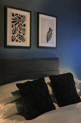 a bedroom with two pictures on the wall and a bed at Gordon's Getaway Lux in Oban