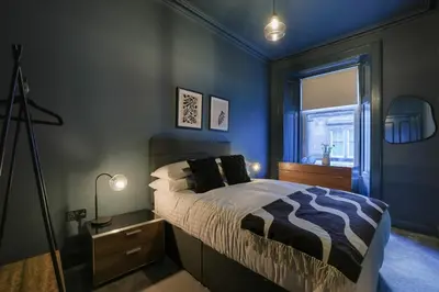 a blue bedroom with a bed and a window at Gordon's Getaway Lux in Oban