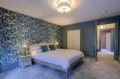 a bedroom with a bed with a blue and green wall at Gordon's Getaway Lux in Oban