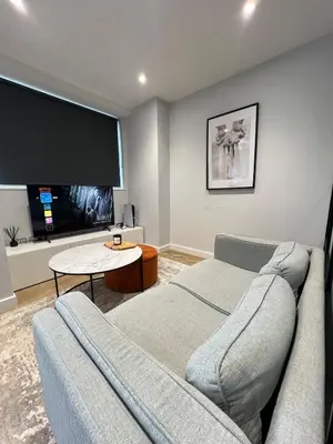 a living room with a couch and a flat screen tv at Modern City Apartment, Fast Wi-Fi, Great View in Moffat