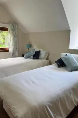 two white beds in a room with a window at Holiday Home Benmore Farm House in Stirling mit Bergblick by Interhome in Crianlarich