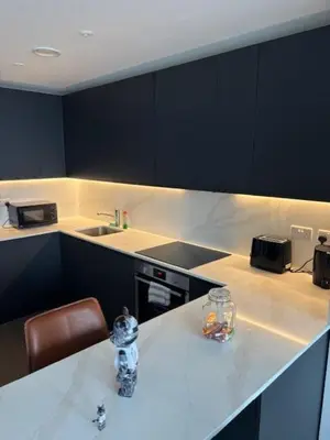 a kitchen with a white counter top with a sink and a table at Skyline view 2 bedroom apartment in Moffat