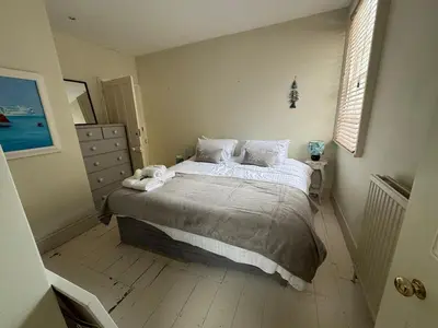 a bedroom with a bed with white sheets and pillows at Regents House, ground floor apartment with sea views in Moffat