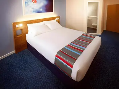 a large white bed in a hotel room at Travelodge Edinburgh Dreghorn in Edinburgh