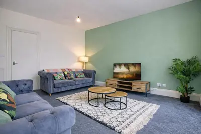 a living room with a couch and a table at Group Stay 4BR Sleeps 11 Spacious with Parking in Glasgow