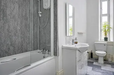 a bathroom with a shower and a sink and a toilet at Group Stay 4BR Sleeps 11 Spacious with Parking in Glasgow