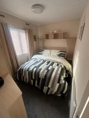 a bedroom with a bed in a small room at Sandylands caravan park in Stevenston