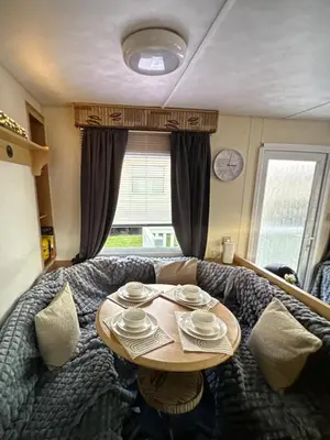 a room with a table with plates on it at Sandylands caravan park in Stevenston