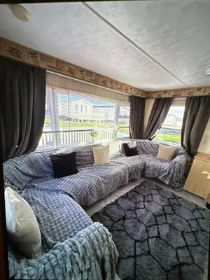 a bedroom with two beds in front of a window at Sandylands caravan park in Stevenston