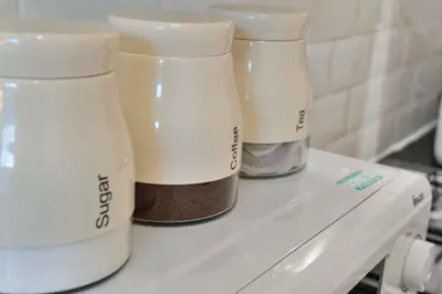 three white containers sitting on top of a counter at Charming City View Apartment with Modern Comforts in Edinburgh