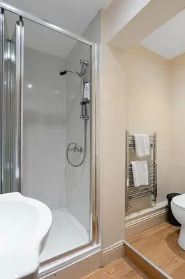 a bathroom with a shower and a sink and a toilet at Charming City View Apartment with Modern Comforts in Edinburgh