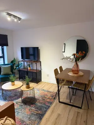 a living room with a table and chairs and a mirror at 2BR Sleeps 4 Albion Gate Glasgow City Centre in Glasgow