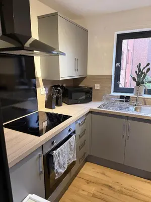 a kitchen with a stove top oven next to a sink at 2BR Sleeps 4 Albion Gate Glasgow City Centre in Glasgow