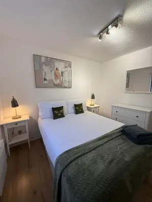 a bedroom with a large white bed with two tables at 2BR Sleeps 4 Albion Gate Glasgow City Centre in Glasgow
