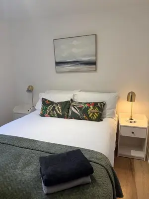 a bedroom with a bed and a picture on the wall at 2BR Sleeps 4 Albion Gate Glasgow City Centre in Glasgow