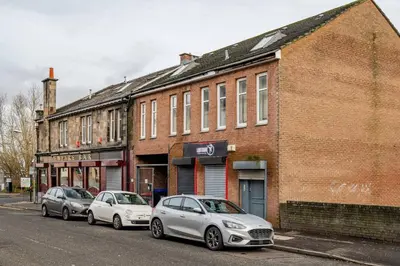 three cars parked in front of a brick building at Cosy Retreat - Suite 5 in Hamilton