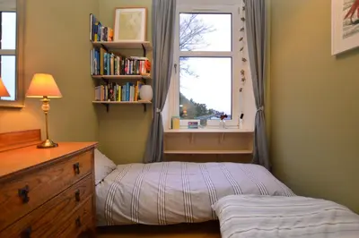 a small bedroom with a bed and a window at Montford Shore in Rothesay