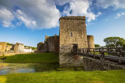 a castle with a bridge over a river at Montford Shore in Rothesay