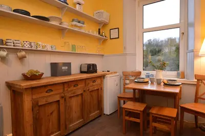 a kitchen with a counter and a table and chairs at Montford Shore in Rothesay