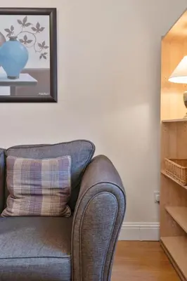 a couch in a living room with a picture on the wall at Great location Edinburgh city centre in Edinburgh